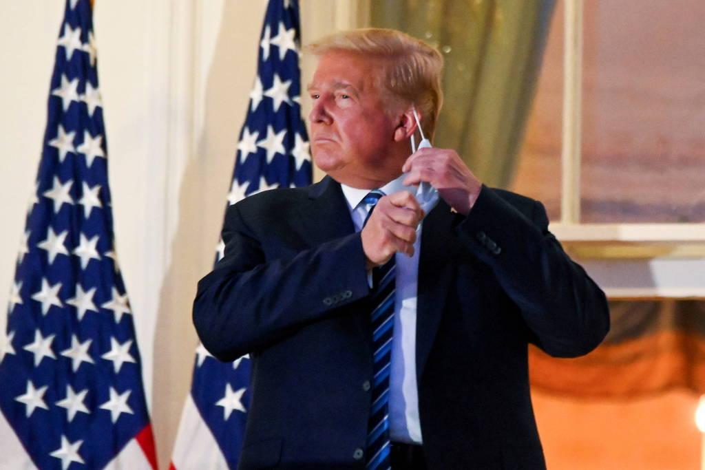Então presidente dos EUA, Donald Trump retira máscara ao chegar à Casa Branca após ter sido internado com Covid-19