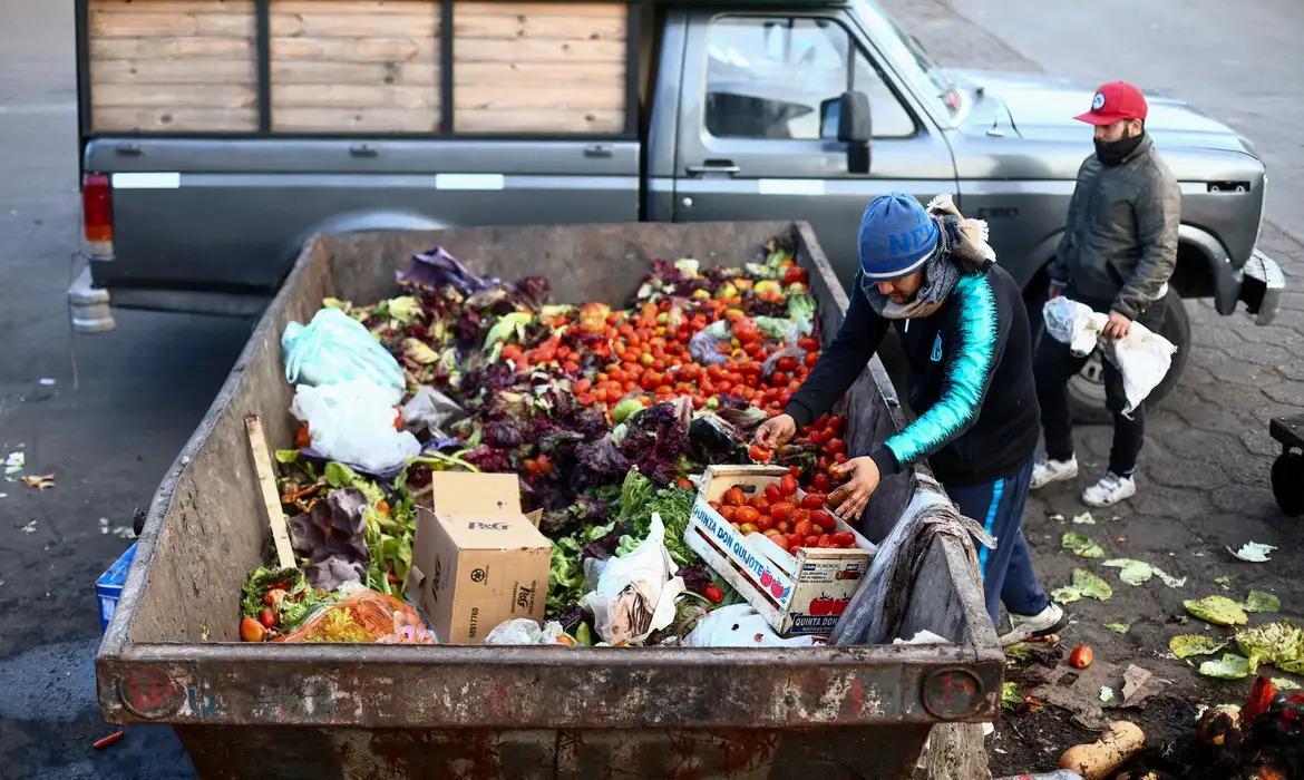 Na imagem, um argentino buscando alimento entre os descartados