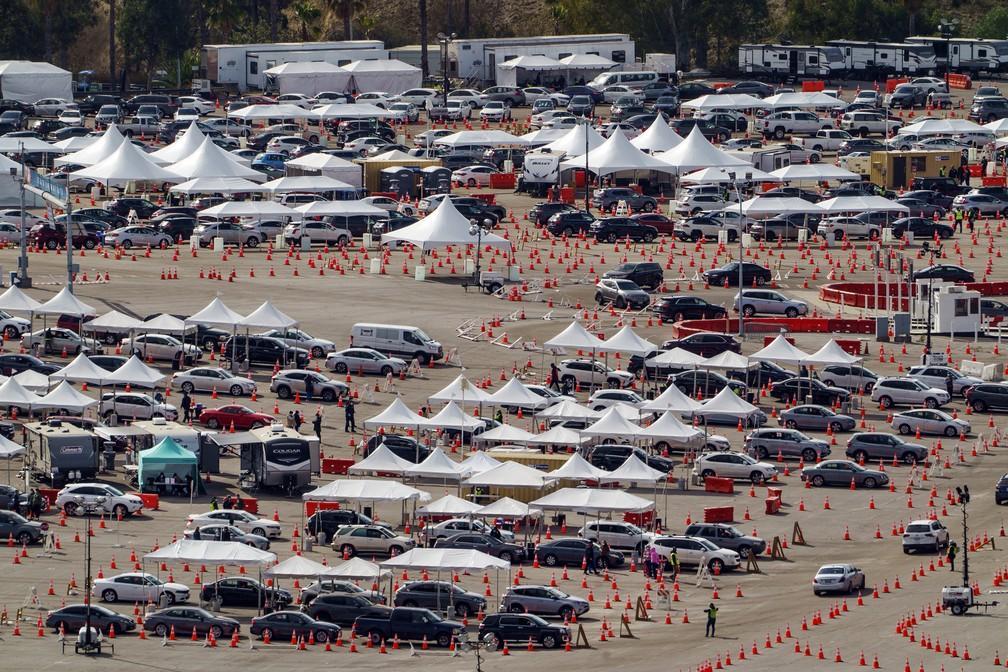 Motoristas fazem fila em mega campanha de vacinação contra a Covid-19 no estacionamento do estádio de baseball do Los Angeles Dodgers em Los Angeles, na Califórnia, na quarta-feira (27)