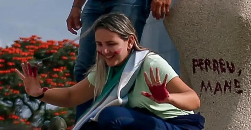 Débora Rodrigues dos Santos, conhecida como “Débora do Batom”, no momento em que pichou a frase “perdeu, mané” na estátua da Justiça, durante o 8 de Janeiro, em Brasília