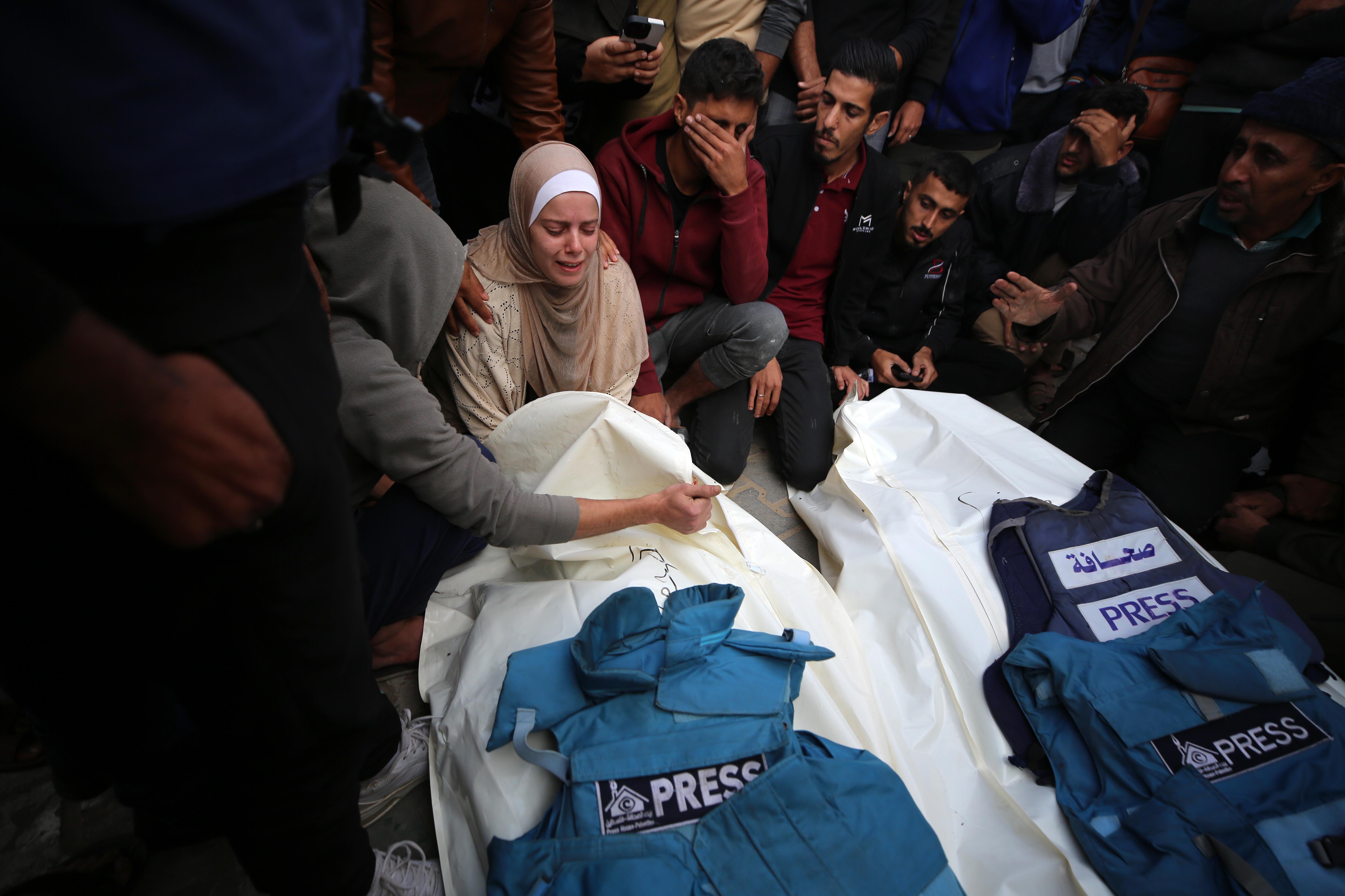 Jornalistas, amigos e família rezando nos corpos dos jornalistas Sari Mansour e Hassouna Esleem, após eles serem mortos em bombardeio israelense