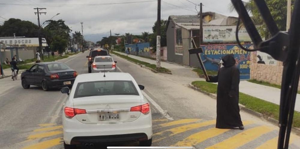 Homem vestido de morte recepciona turistas que insistiram em ir ao Litoral Norte de SP