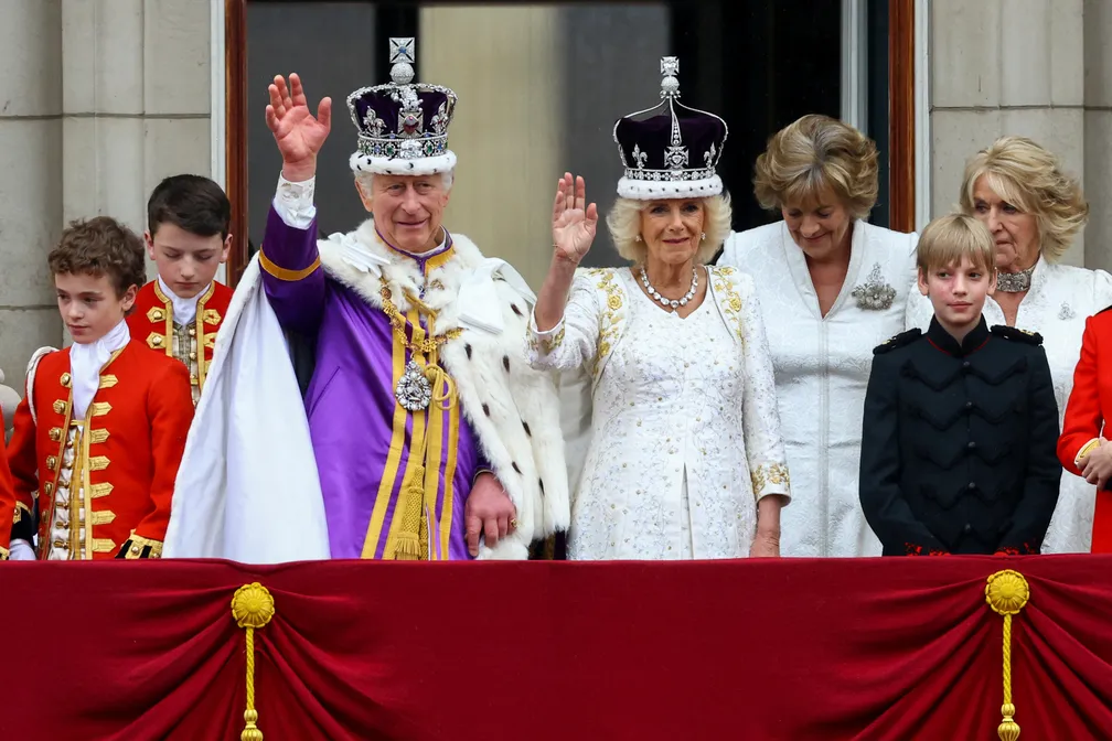 O rei Charles III e a rainha Camilla, do Reino Unido, acenam da sacada do Palácio de Buckingham após a cerimônia de coroação, em Londres