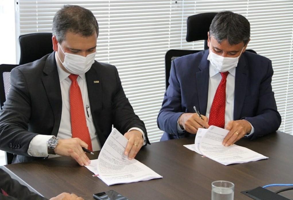 Wellington Dias e o diretor do BRB assinando o contrato