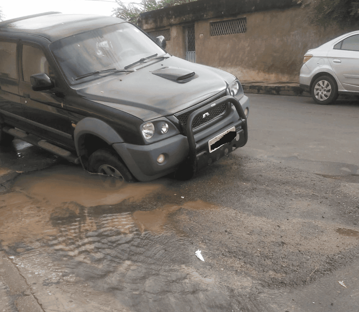 Asfalto cede e carro fica preso em buraco no bairro Tabuleta