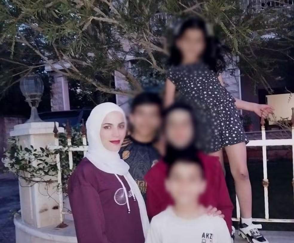 Mãe e filhos de 10 e 9 anos (de véu preto e camiseta branca) ficam feridos em ataque aéreo