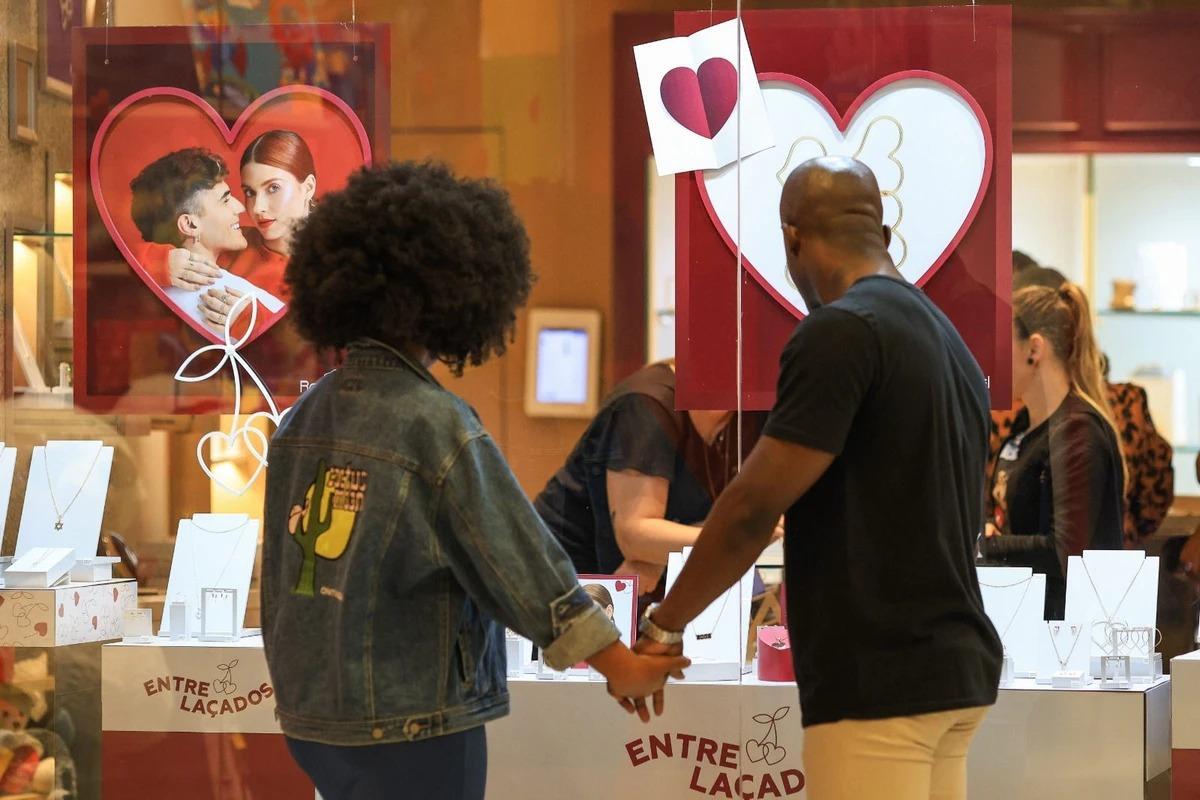 Casal observa produtos na vitrine de uma loja de shopping em Belo Horizonte